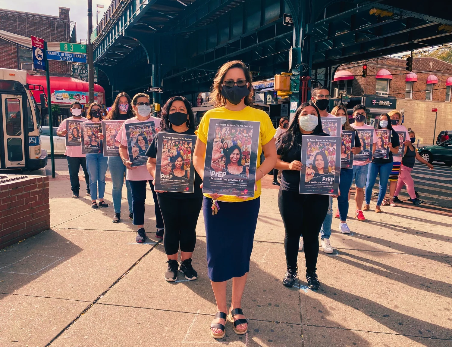 Participants carrying illustrated portrait posters through a city street procession.